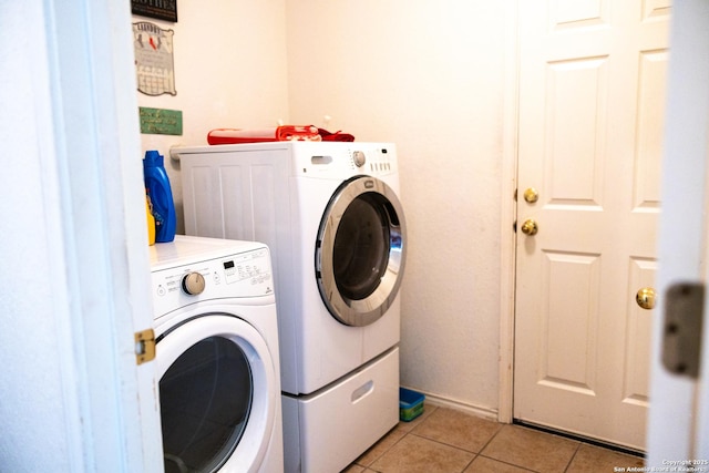 clothes washing area with laundry area, light tile patterned floors, and washing machine and clothes dryer