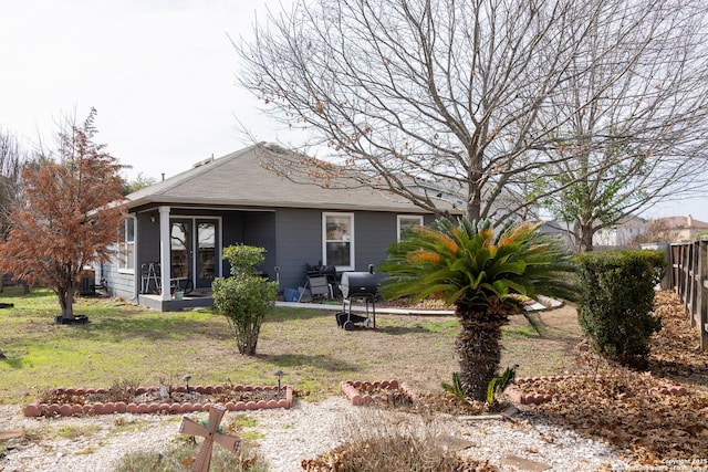 back of house with a sunroom and a yard