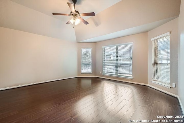 spare room with dark wood-style floors, a wealth of natural light, lofted ceiling, and baseboards