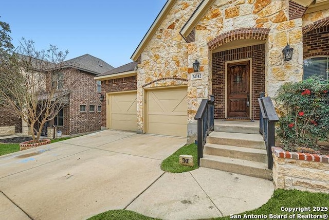 property entrance with a garage, stone siding, brick siding, and driveway