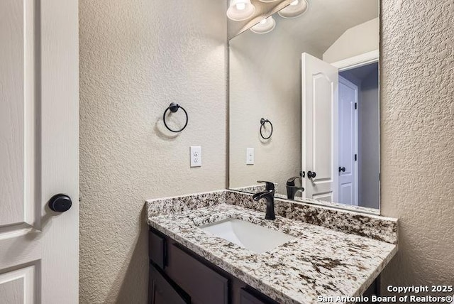 bathroom featuring a textured wall and vanity