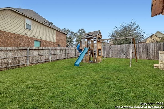 view of play area featuring a lawn and a fenced backyard