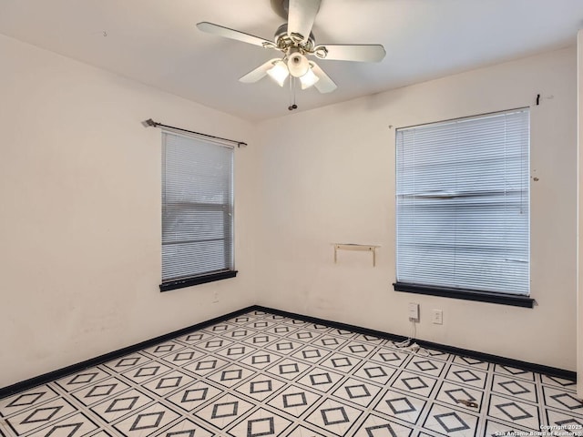 empty room featuring ceiling fan and baseboards