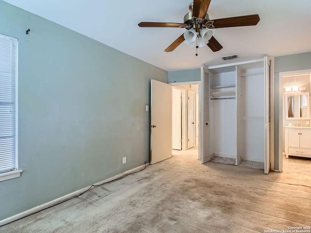 unfurnished bedroom with light carpet, visible vents, baseboards, ensuite bath, and a closet