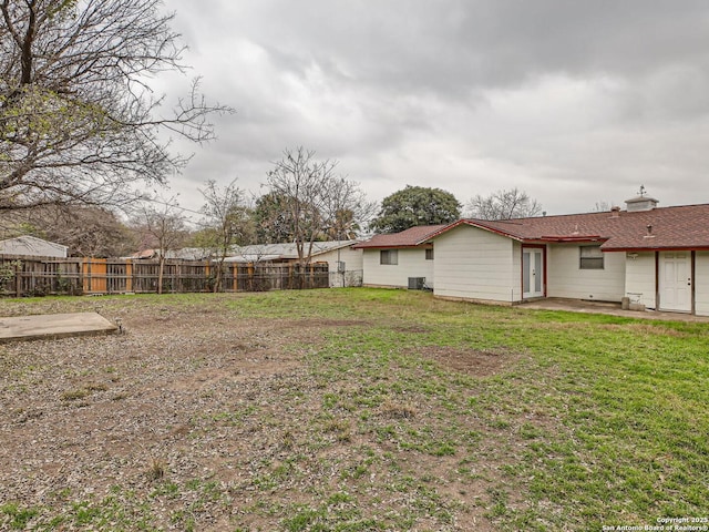 view of yard featuring central AC, a patio area, and fence