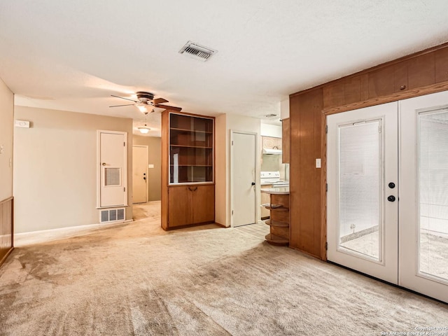 interior space with light carpet, visible vents, a ceiling fan, and french doors