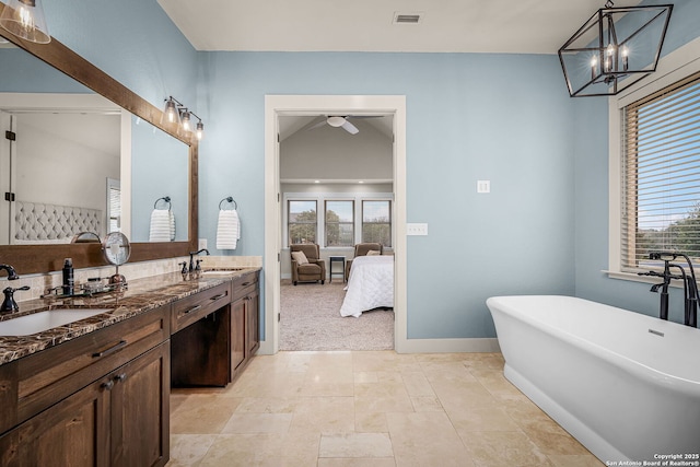 full bath with ensuite bathroom, a freestanding tub, a sink, and visible vents