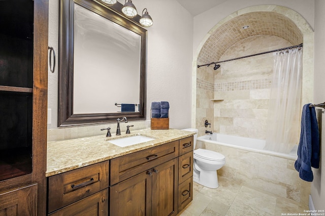 full bath featuring tiled shower / bath combo, vanity, and toilet