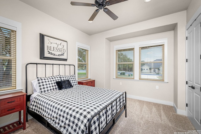 bedroom featuring multiple windows, carpet flooring, a ceiling fan, and baseboards