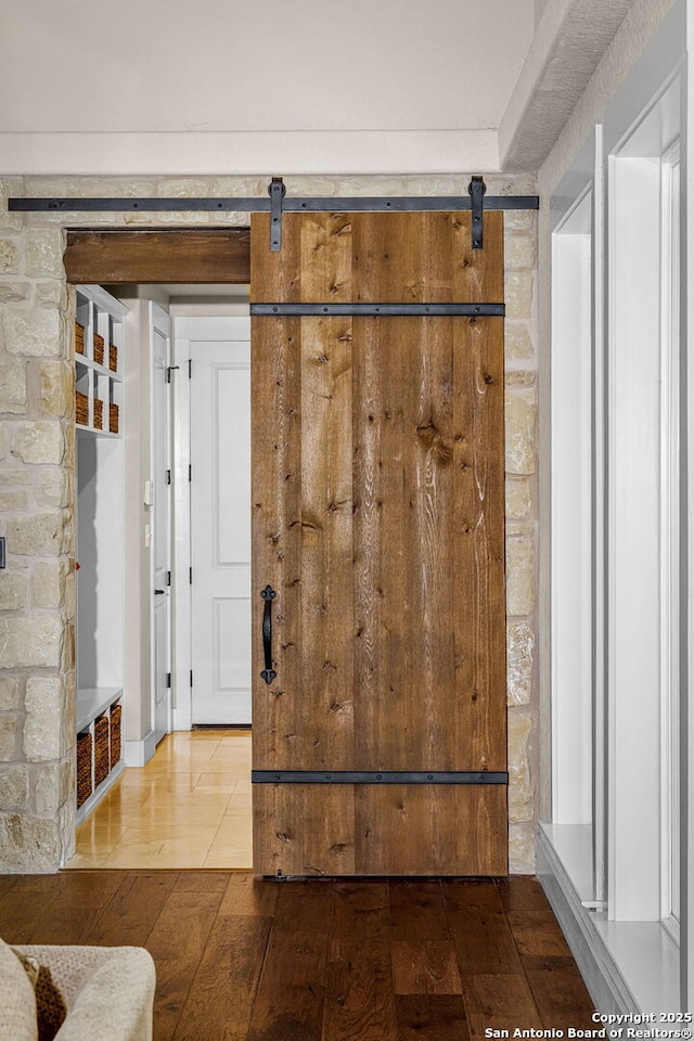 interior space featuring wood finished floors and a barn door