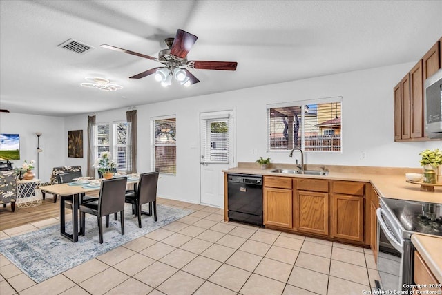 kitchen featuring visible vents, appliances with stainless steel finishes, brown cabinets, light countertops, and a sink