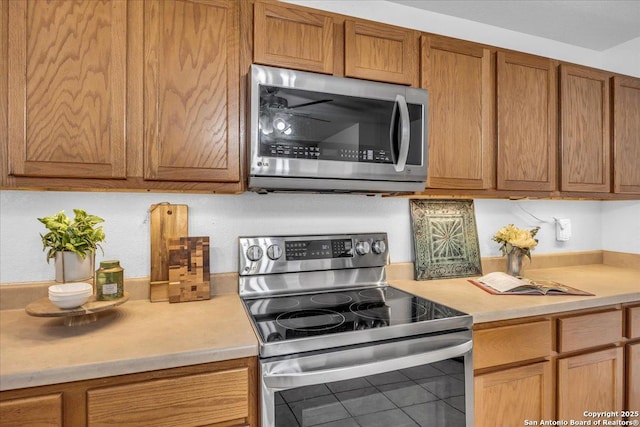 kitchen featuring light countertops, appliances with stainless steel finishes, and brown cabinets