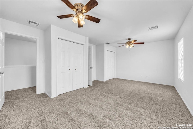 unfurnished bedroom featuring a ceiling fan, baseboards, visible vents, and carpet flooring