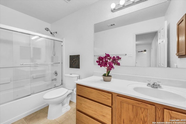 bathroom with visible vents, bath / shower combo with glass door, toilet, tile patterned floors, and vanity