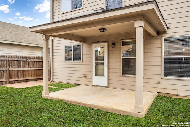 doorway to property with a lawn, a patio area, and fence