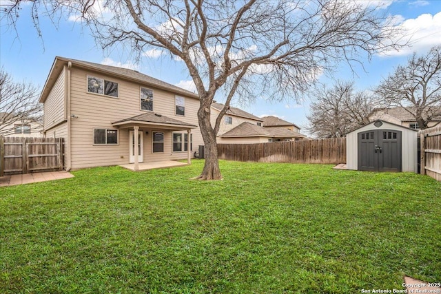 rear view of house with an outbuilding, a fenced backyard, a storage shed, a yard, and a patio area