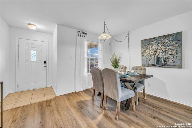 dining space with baseboards and wood finished floors