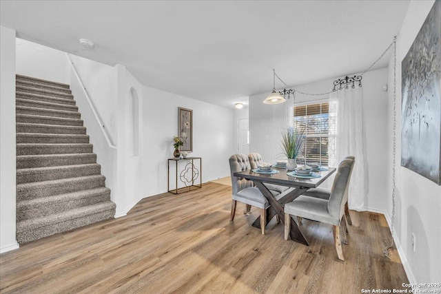 dining space featuring stairs and wood finished floors