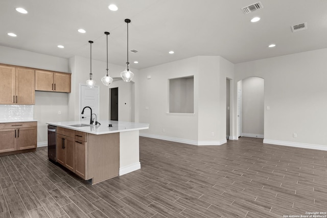 kitchen featuring visible vents, arched walkways, a kitchen island with sink, light countertops, and a sink