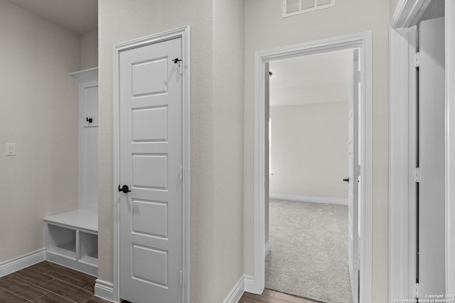 mudroom with wood finish floors, visible vents, and baseboards