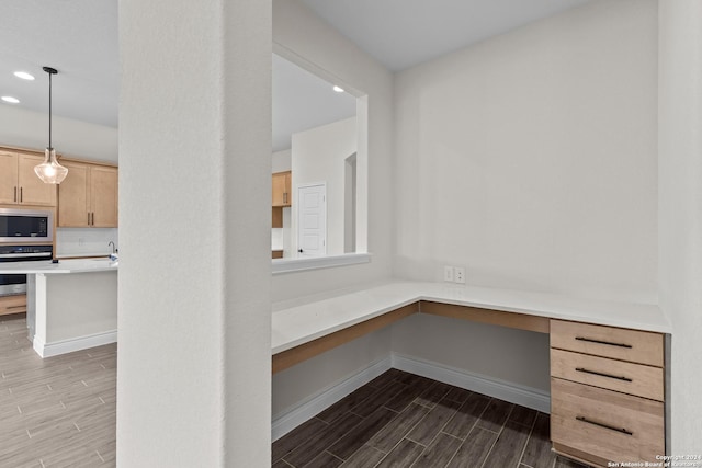 unfurnished office featuring baseboards, built in desk, recessed lighting, and wood tiled floor