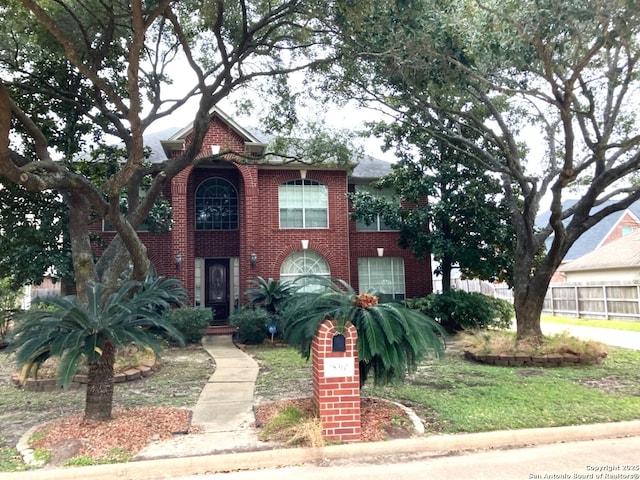 view of front of property featuring brick siding and fence