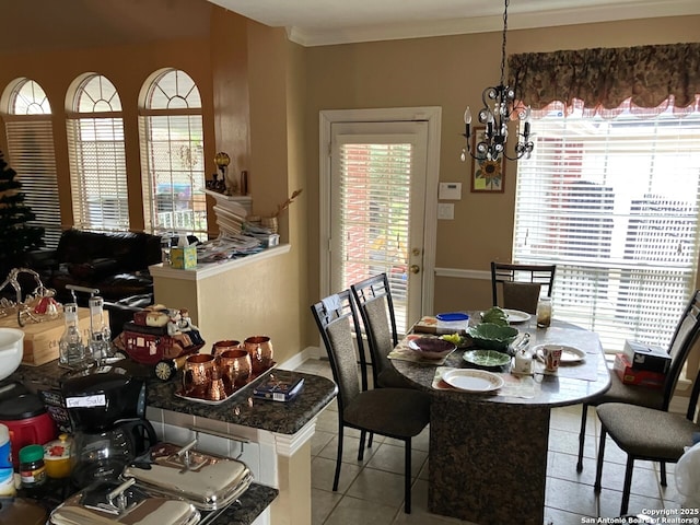 dining space featuring light tile patterned floors, ornamental molding, and a notable chandelier