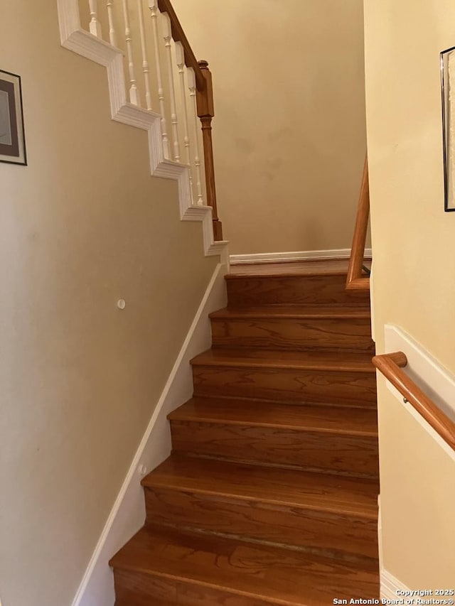 stairs with baseboards and wood finished floors