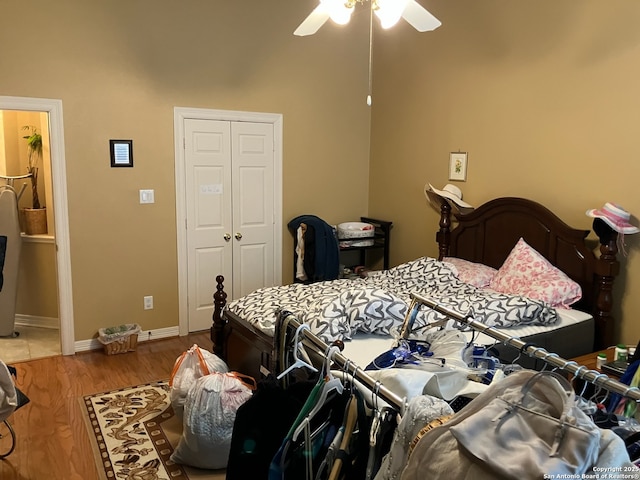 bedroom featuring ceiling fan, a closet, wood finished floors, and baseboards