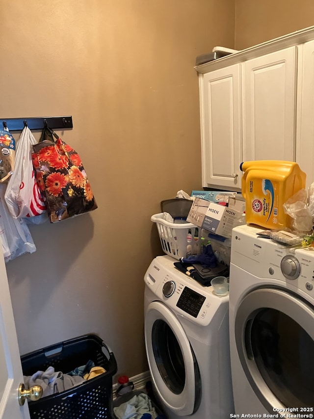 washroom featuring cabinet space and washing machine and clothes dryer