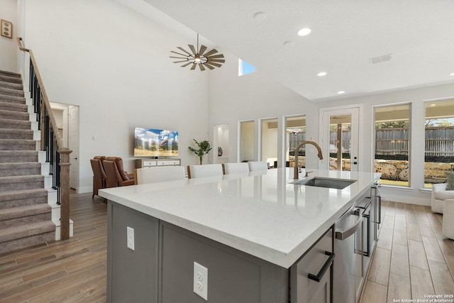 kitchen featuring plenty of natural light, an island with sink, open floor plan, and a sink