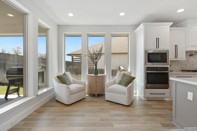 living area featuring recessed lighting, a healthy amount of sunlight, and wood tiled floor