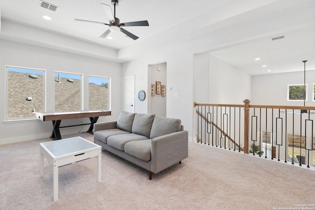 living room with a wealth of natural light, visible vents, and carpet flooring