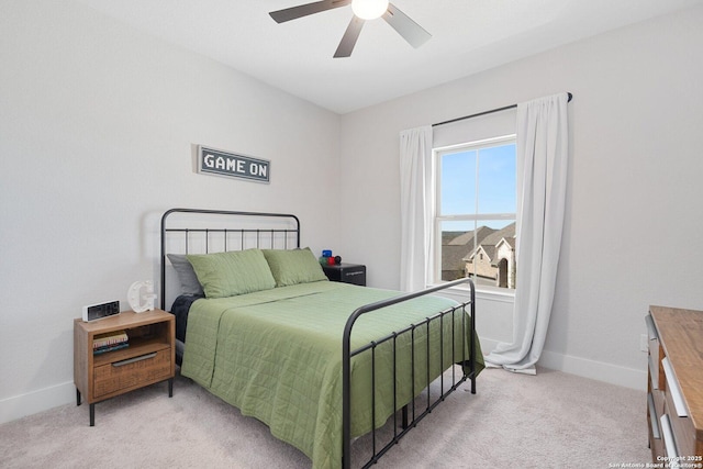 bedroom featuring baseboards, light colored carpet, and ceiling fan