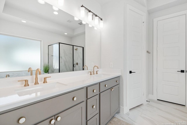 bathroom with double vanity, marble finish floor, a marble finish shower, and a sink