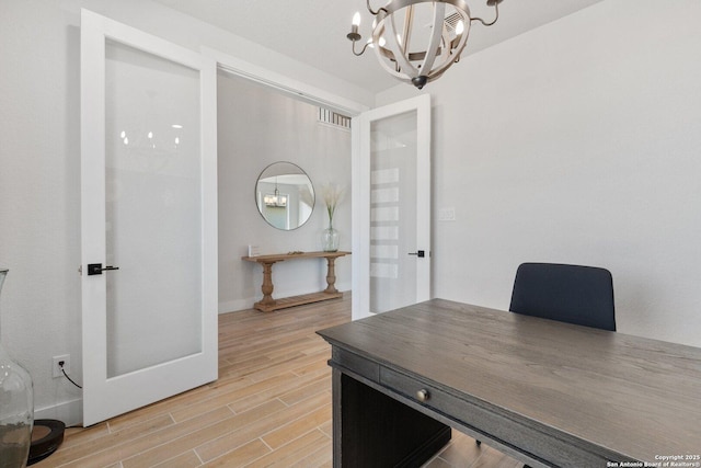 home office with a notable chandelier and wood tiled floor