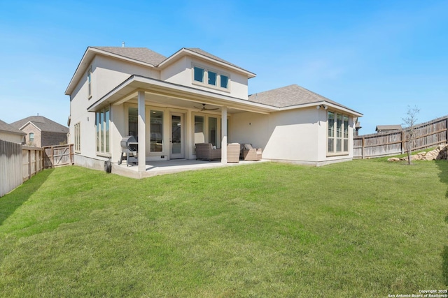 rear view of property featuring stucco siding, a lawn, a patio, a fenced backyard, and ceiling fan