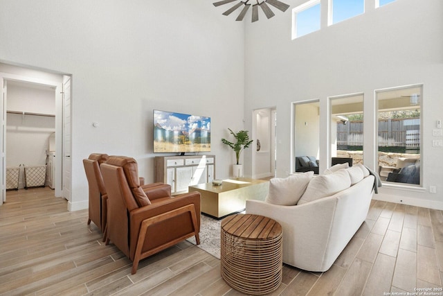 living room featuring baseboards, a ceiling fan, and wood tiled floor