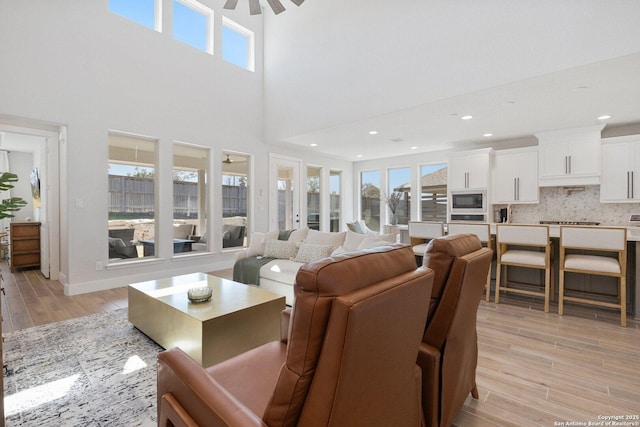 living room featuring recessed lighting, a healthy amount of sunlight, light wood-type flooring, and a ceiling fan