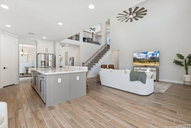 kitchen with light countertops, stainless steel fridge with ice dispenser, and wood finish floors