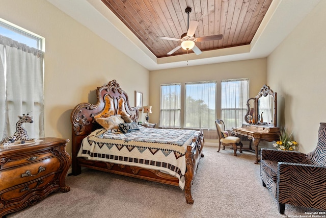 bedroom with carpet floors, wood ceiling, a raised ceiling, and ceiling fan