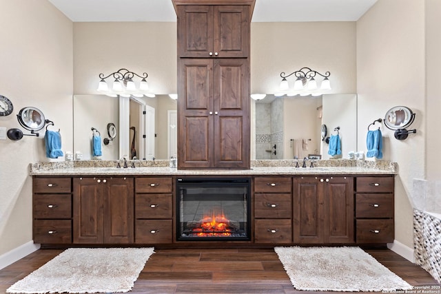 full bath featuring baseboards, wood finished floors, and vanity