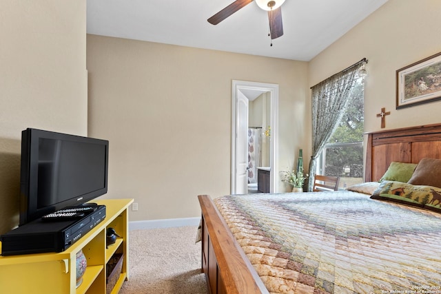 bedroom featuring light colored carpet, ceiling fan, ensuite bath, and baseboards