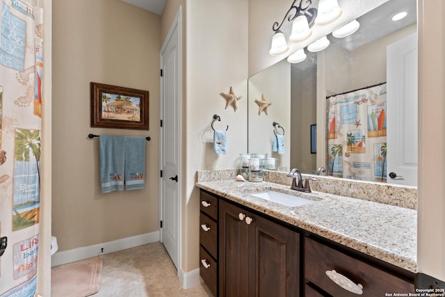 full bath with baseboards, vanity, and tile patterned floors