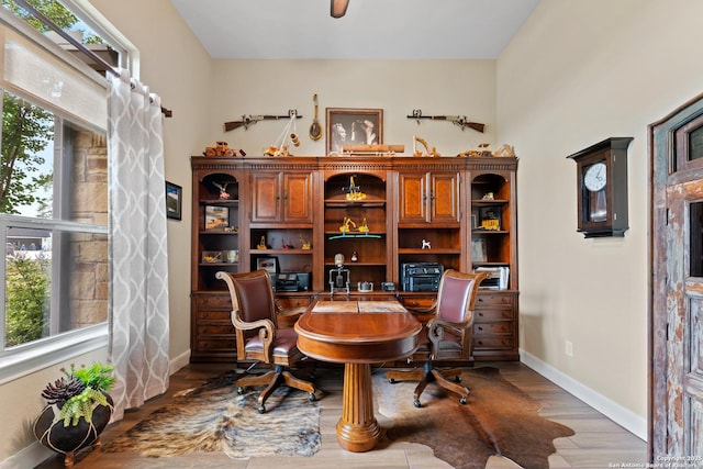 office area featuring wood finished floors, built in study area, and baseboards