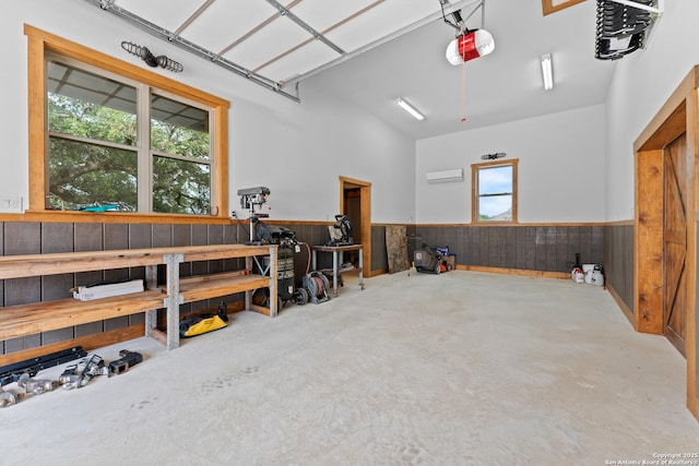 garage featuring a garage door opener, a wainscoted wall, and wooden walls