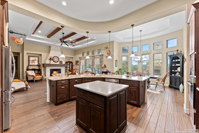 kitchen with hanging light fixtures, a kitchen island, and a raised ceiling