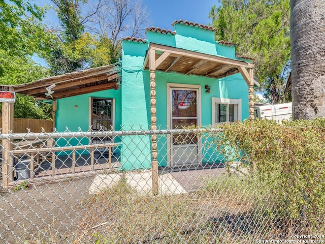 view of side of home featuring fence and stucco siding