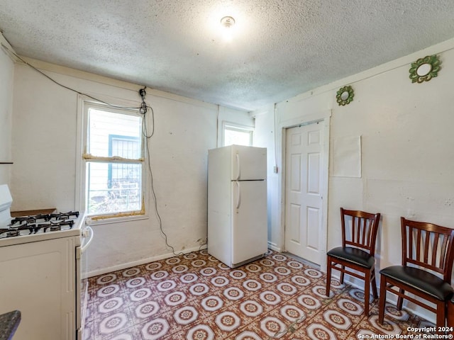 3315 Pitluk Ave, San Antonio, TX 78211 - kitchen featuring white appliances, light tile patterned floors, and a textured ceiling