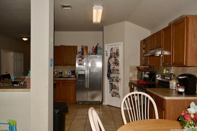 kitchen featuring under cabinet range hood, appliances with stainless steel finishes, and brown cabinetry